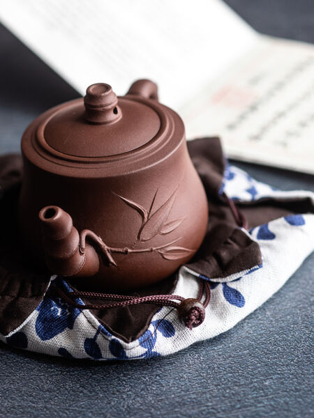 Yixing Teapots: History, Clay, and Craft Handmade in China, our Shuye Teapot (featured on MastersTeas.com) is a Pan Hu shape and made from authentic zisha clay. The long spout and handle have been modeled to mimic bamboo, with leaves that adorn the belly. With a max capacity of 230 ml, it is ideal for gong fu style brewing all types of tea. Though it can be used for all types of tea. Yixing clay is extremely porous and absorbent. Hand wash with warm water only and let air dry.